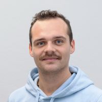 Leon Bieber - Customer Success Manager: Smiling man with brown beard and brown wavy hair.