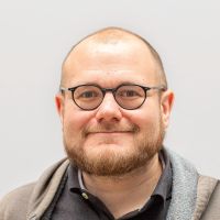Sebastian Metzger: male, bearded and small, round, black glasses