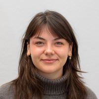 Amelie Reinhard - Business Development Assistant: Smiling woman with black bob haircut.