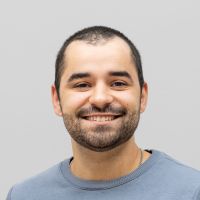 Ilja Suslik - Business Development Assistant: Smiling man with short black beard and hair.