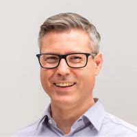Marcus Klapprodt - Head of Operations: Smiling man with grey hair and square, thick, black glasses