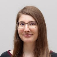 Mona Röhn - Developer: Smiling woman with brown eyes; brown, long. straight hair and rounded, large glasses.
