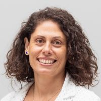 Roberta Palumbo - Customer Success Manager: Smiling woman with shoulder-length curly auburn hair and brown eyes.