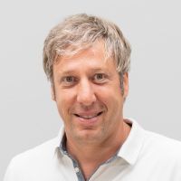 Roland Hötzl: male, wavy, grey-blond hair and grey-blue eyes
