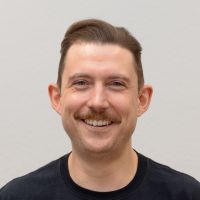 Marian Friedmann - Senior Product Designer: Smiling man with light brown moustache; light brown short hair and blue eyes.